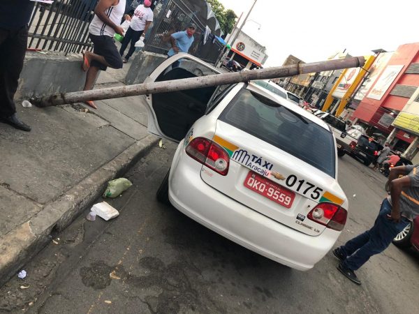 Poste cai em cima táxi no centro de Aracaju