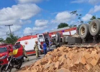 Motorista fica preso às ferragens após capotamento de caminhão com tijolos